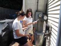 Barnett and Margaret Tsudis ChE ’10 install a meter that provides real-time feedback on energy consumption.