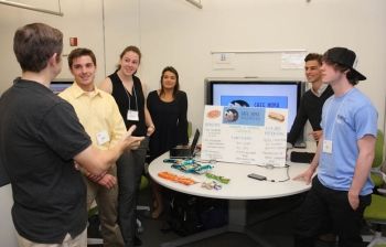 Second place team “Born to Innovate” discusses its “Café Nova Express” concept with II Luscri, director of the ICE Center.