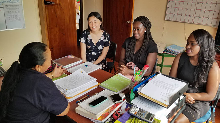 Senior Computer Engineering majors Sarah Chen, Gibel Sowe and Karol Pierre discuss a computer lab and computing education curriculum with the principal of a local school. 