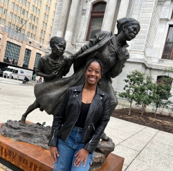 Nadjulia Constant stands in front of Harriet Tubman statue