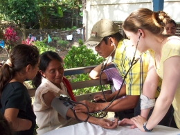 student takes blood pressure of woman in nicaragua