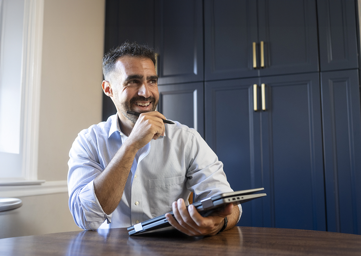 man sitting at a table holding a tablet