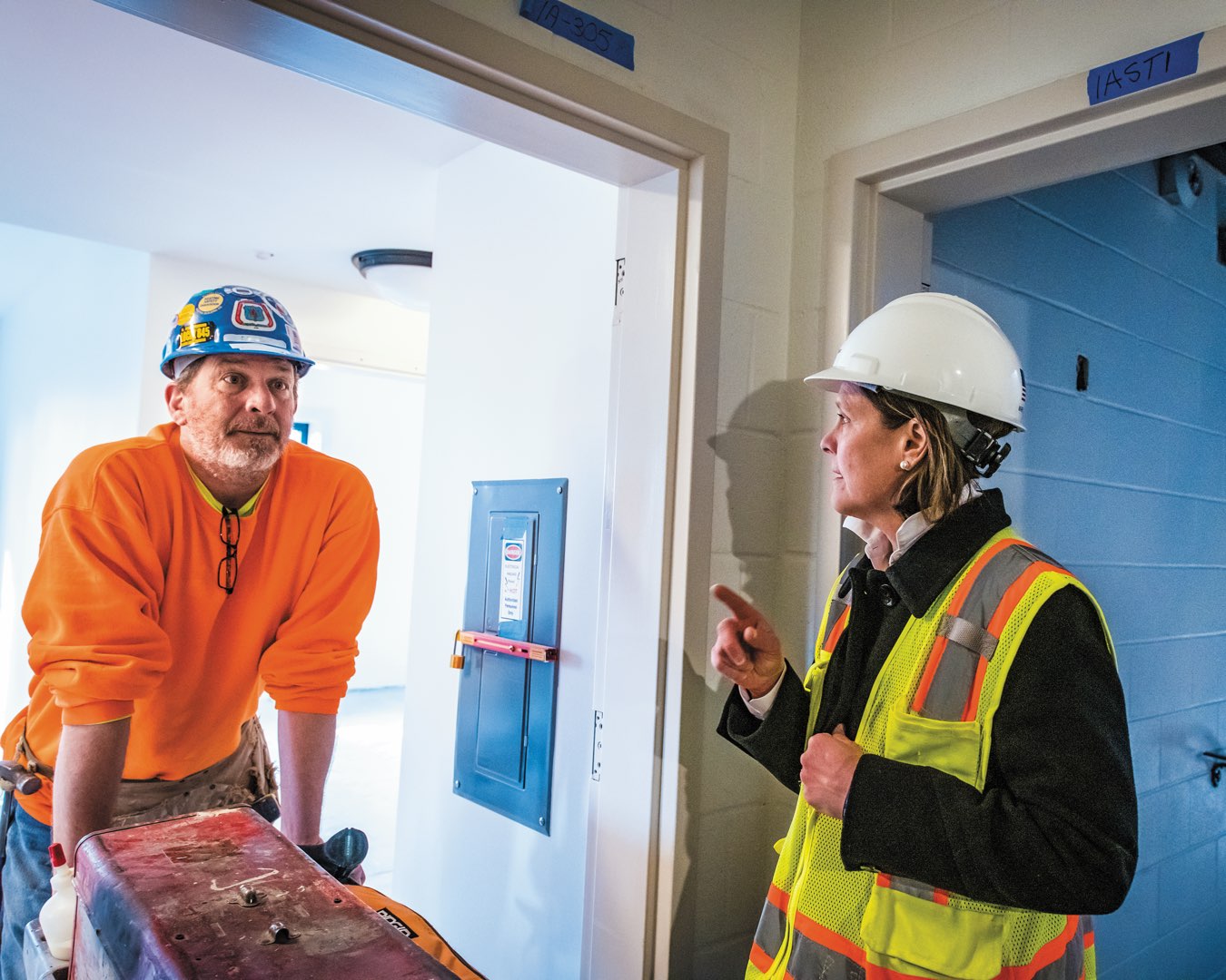 Marilou Smith talks with a contractor working on the interior finishing of The Commons residence halls
