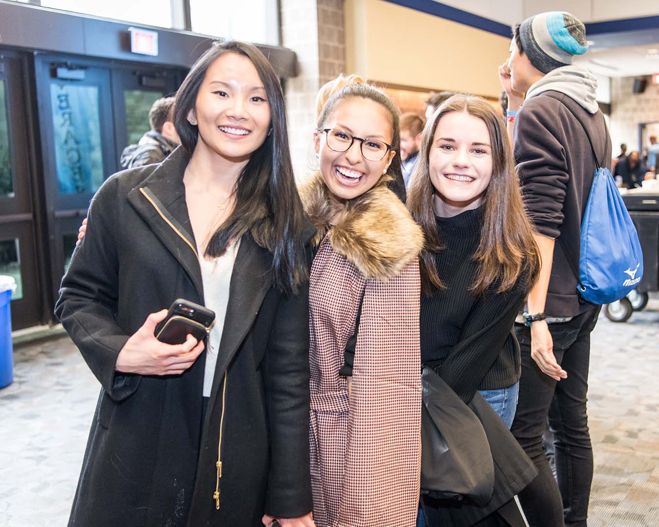 Three young female Villanova alumni with beaming smiles at Homecoming.