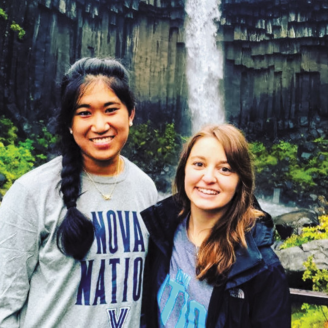 Two female Villanova students wearing Nova Nation shirts in front of the Svartifoss waterfall in Iceland