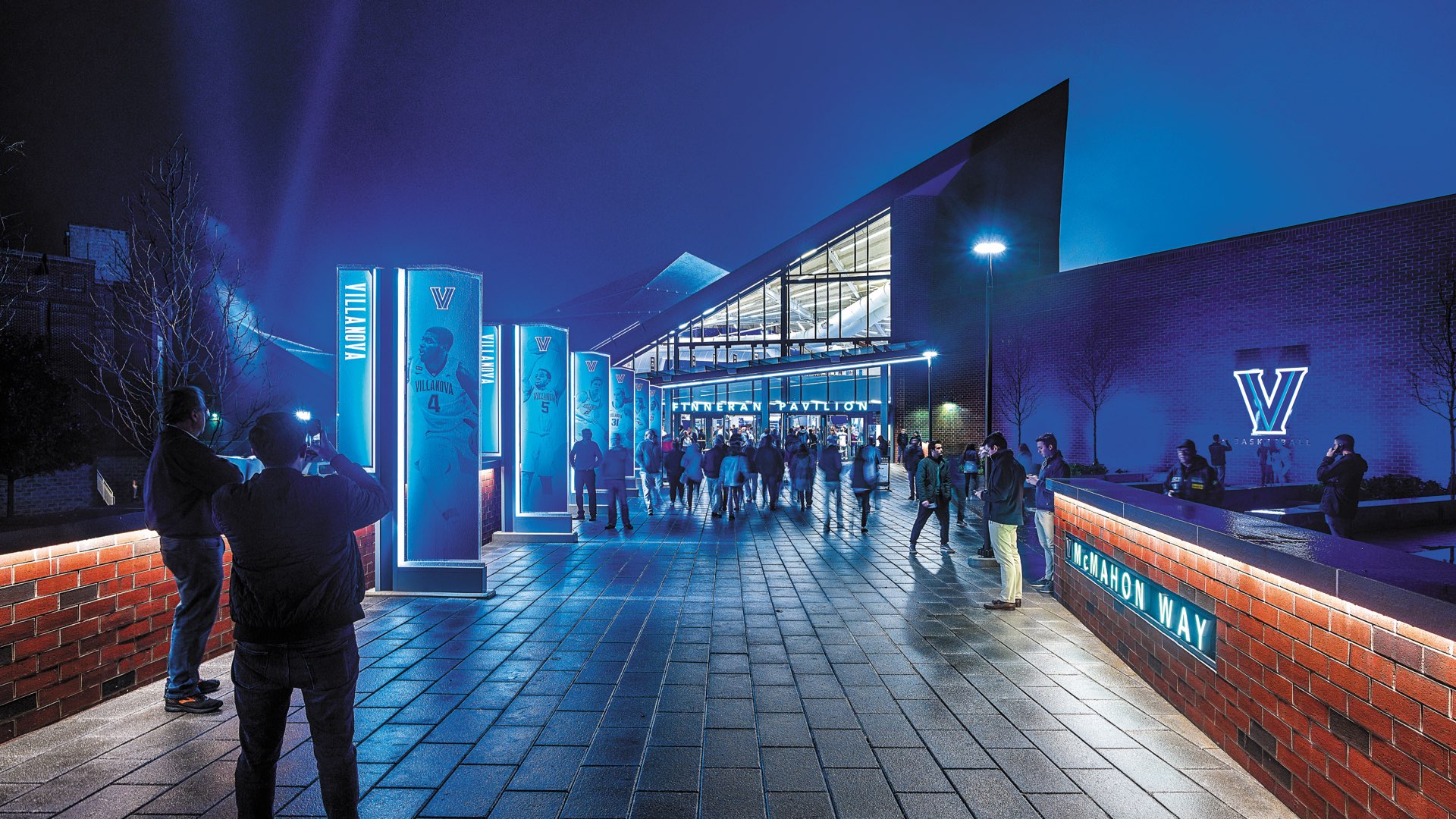 The new Finneran Pavilion at nighttime, with crowds of people entering for a game