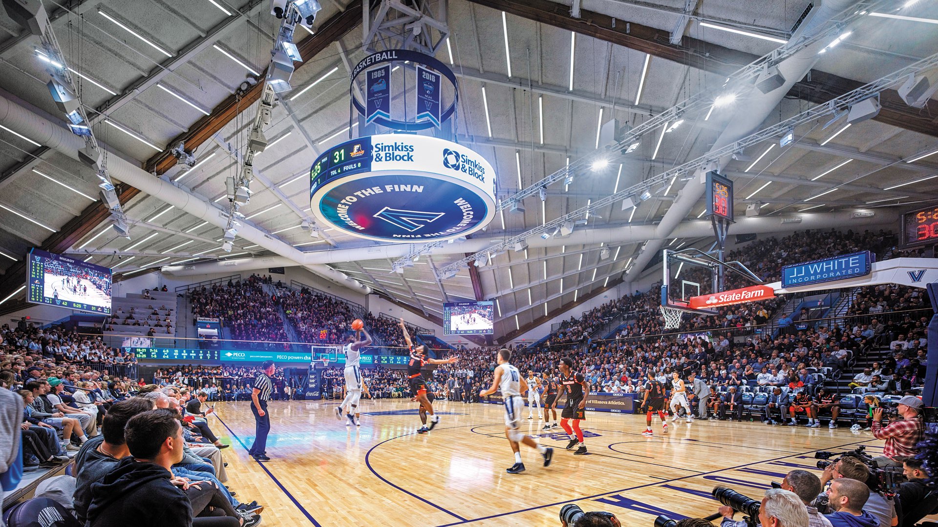 Inside the Finneran Pavilion, Villanova’s Men’s Basketball players in mid-game on the court with packed stands