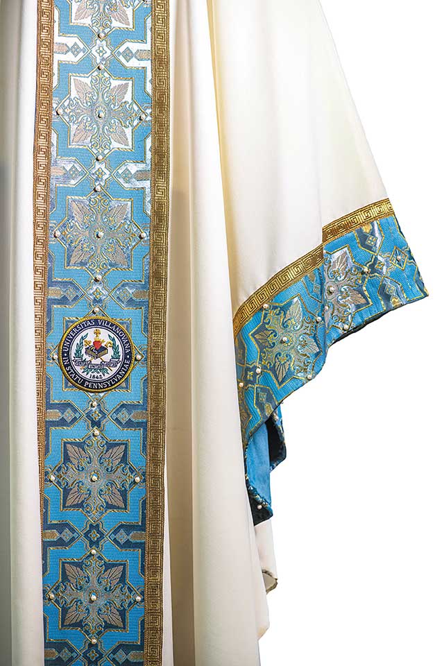 Close-up view of ornate details on Father Canuli’s blue, white, and gold liturgical vestment
