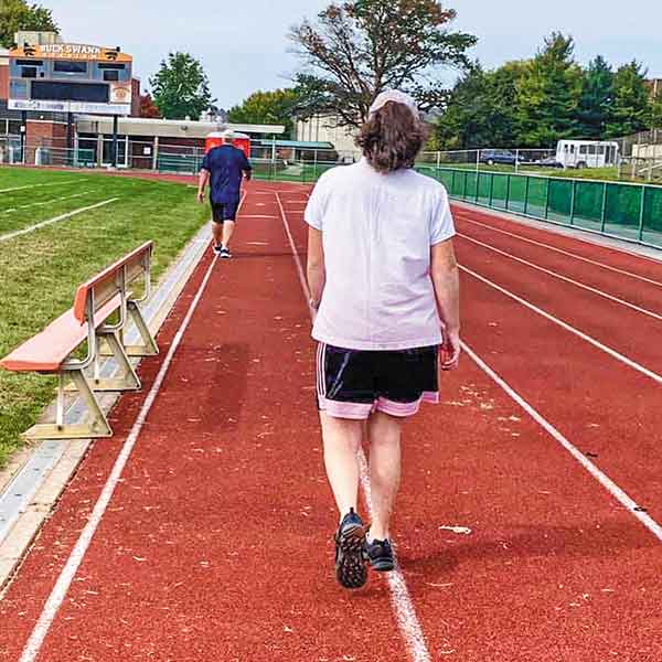 the backs of two athletes walking around a track
