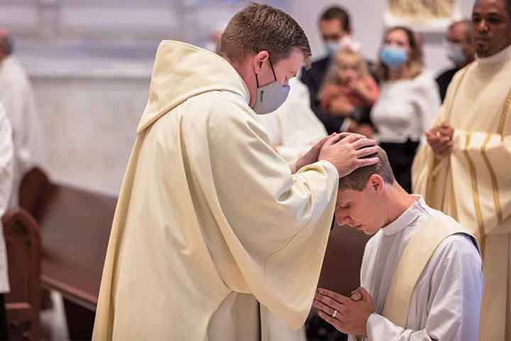 Father Kerns lays hands on the head of the Rev. Daniel Madden, OSA, '11 CLAS during his ordination.