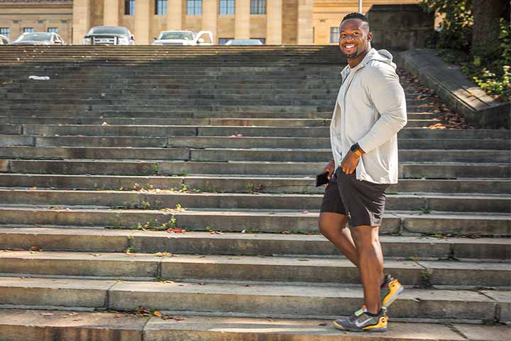 Osayi Osunde wearing workout clothing on the Rocky steps of the Philadelphia Art Museum
