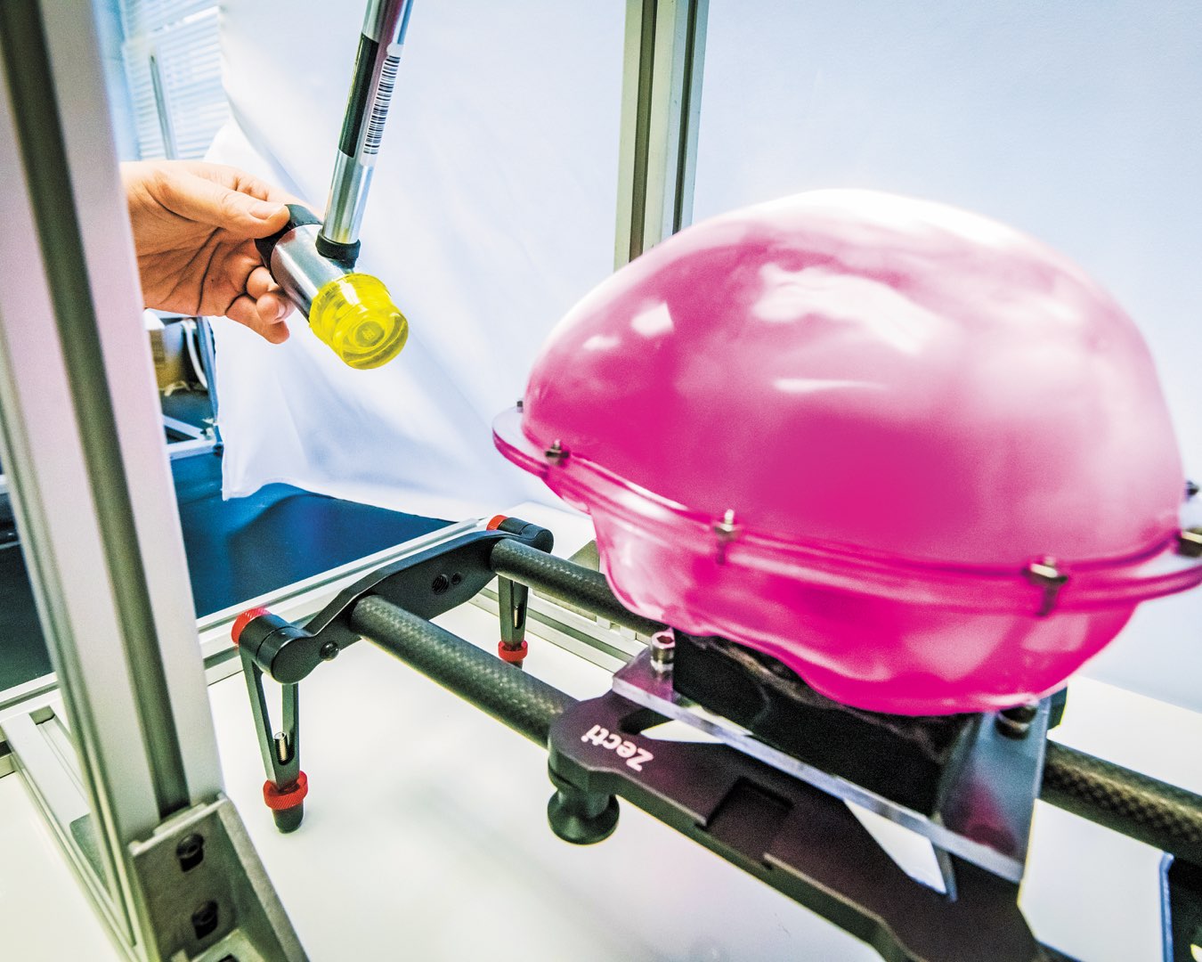Close-up view of hammer preparing to make impact with bright-pink smart brain model