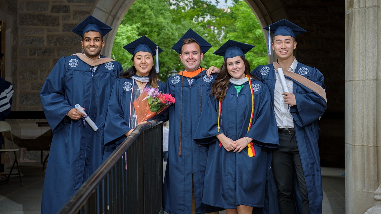 5 Villanova alumni in graduation cap and gowns on campus