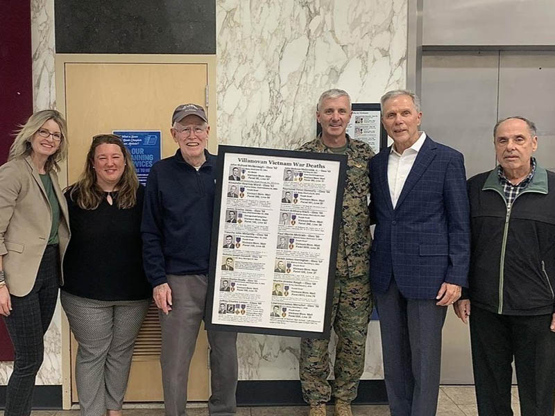 A group displaying the Villanova Vietnam Veterans memorial plaque