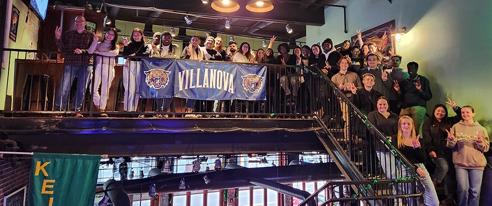 graduate students standing together at happy hour event