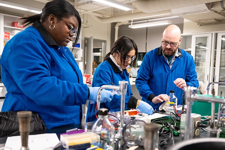 students and faculty working in a science lab