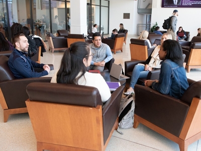 students sitting and chatting in law school commons