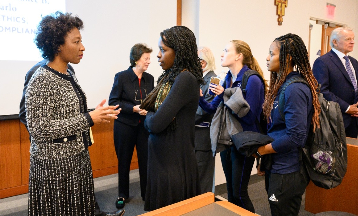 Precious Gittens, Senior Director of Compliance Investigations at Fresenius Medical Care North America, discusses compliance with students after a lecture.