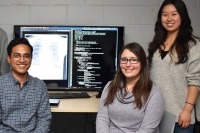 Computer science students sitting in front of computer screens with lines of code