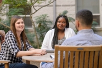 students sitting and talking in the courtyard of the St. Augustine Center