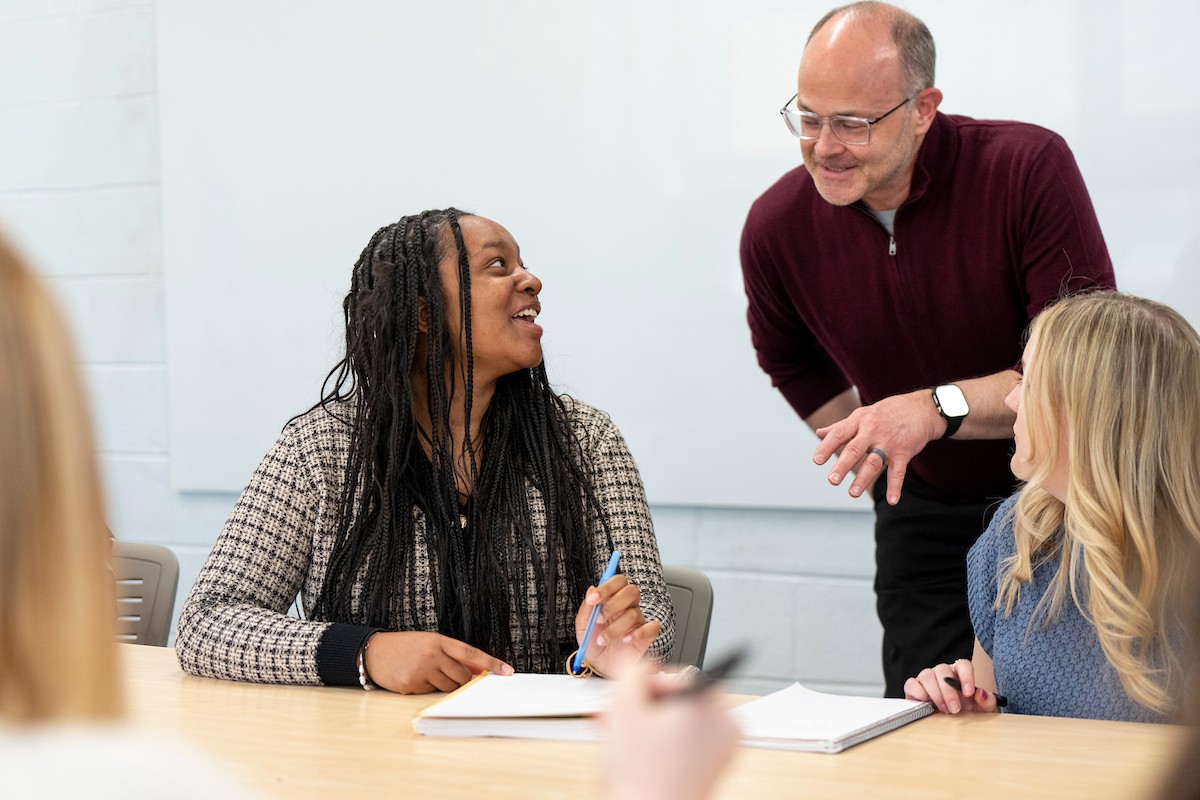 graduate-classroom A Villanova faculty members talks to two students during a class.