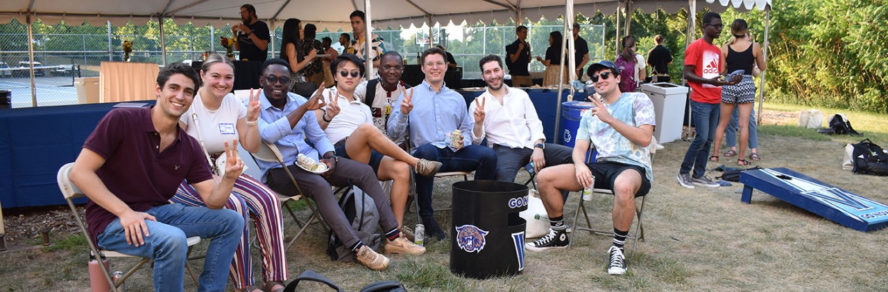 graduate students sitting outside at a picnic