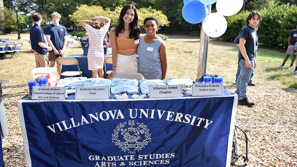 Graduate students staffing an information table at the fall welcome picnic