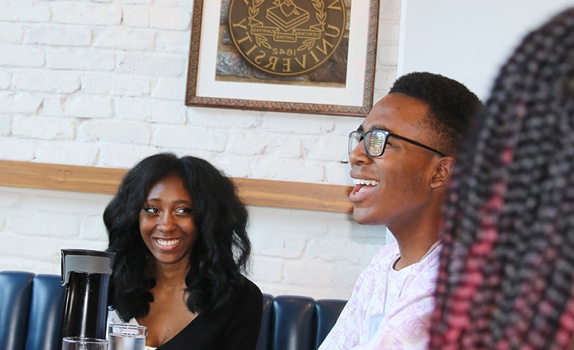 Two student participants smile during a meal.