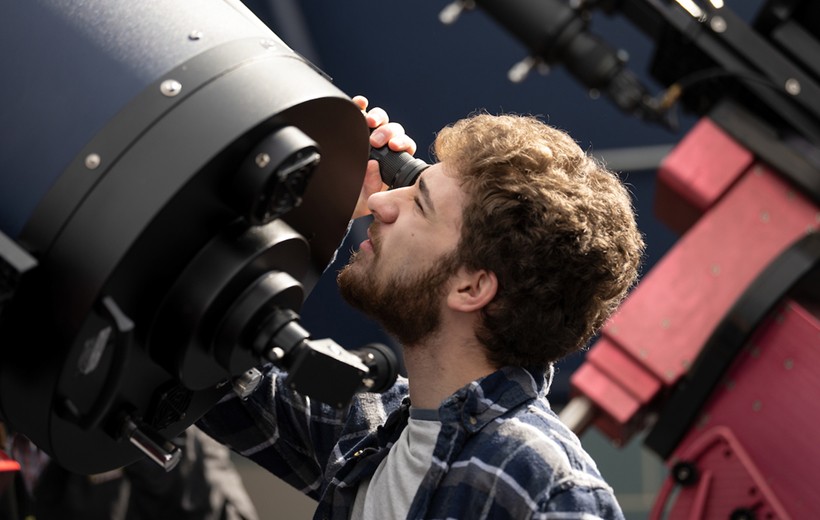 A student works with the rooftop telescope.