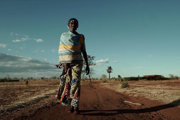 Adija, the subject of the film, walks along a dirt road. 