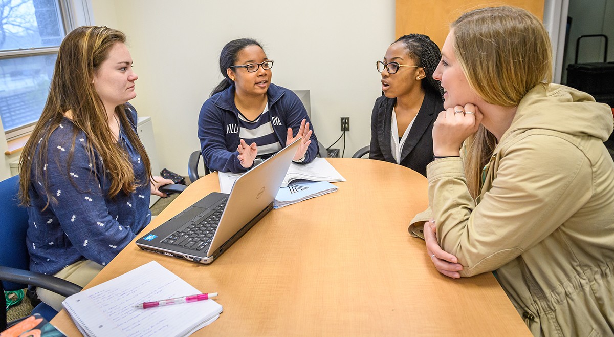 Graduate students in discussion around a conference table