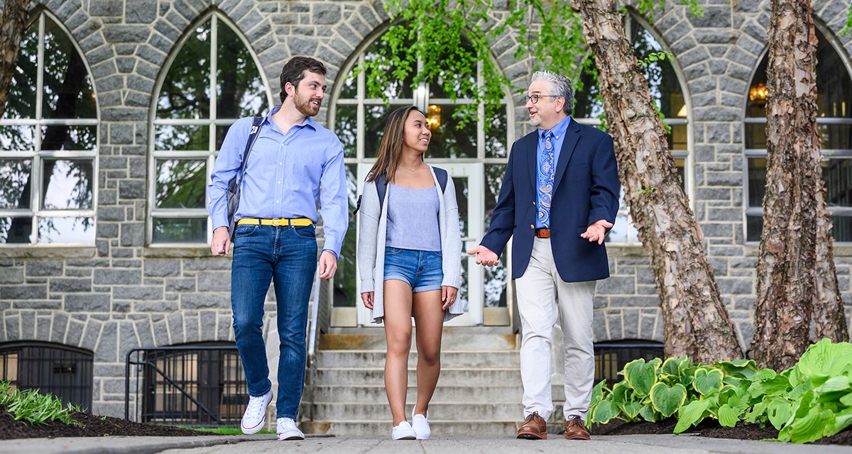 Faculty member walking with Villanova students on campus