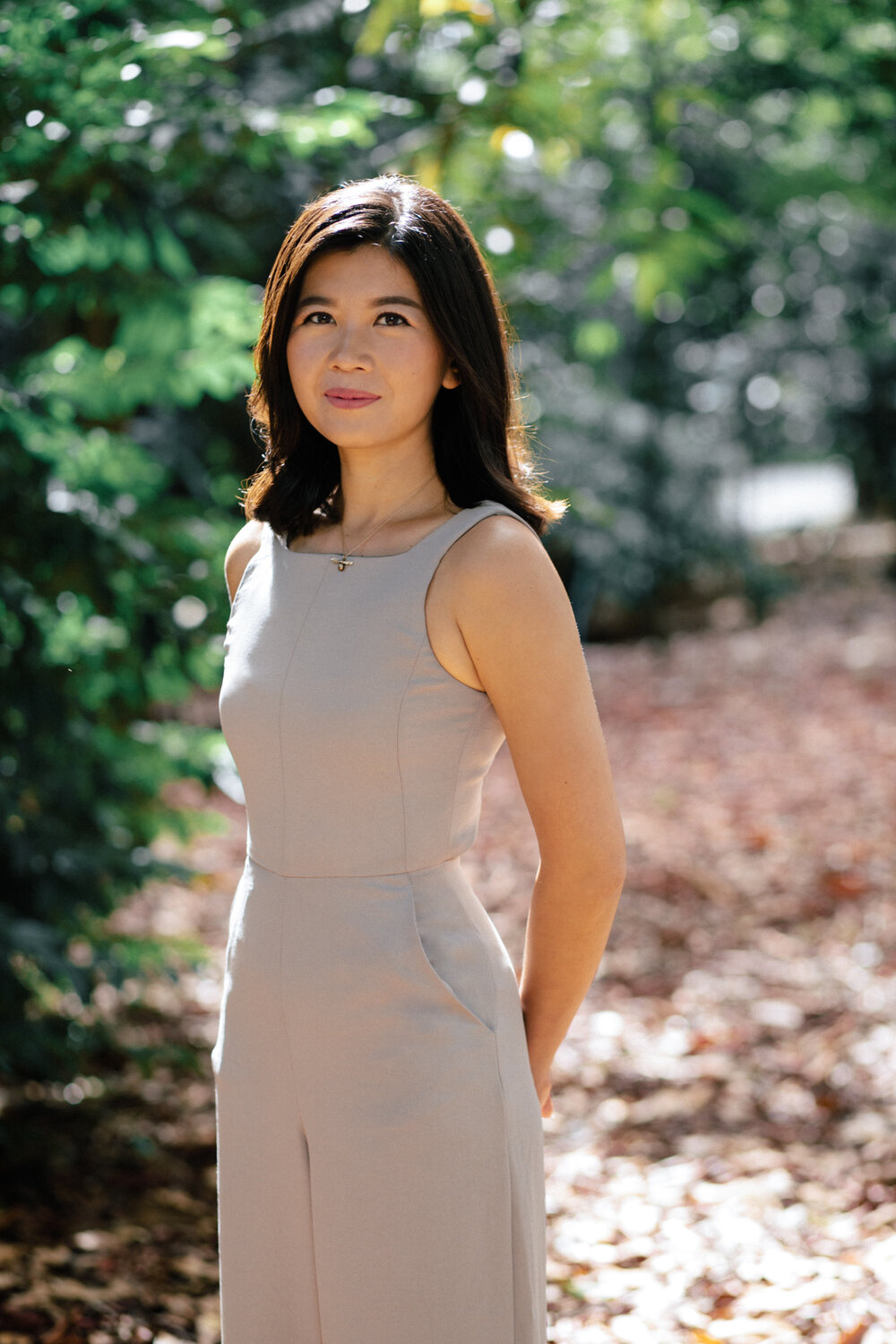 A woman standing by a trail in the woods