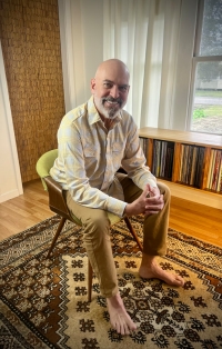 A man sitting in a green chair on a carpet