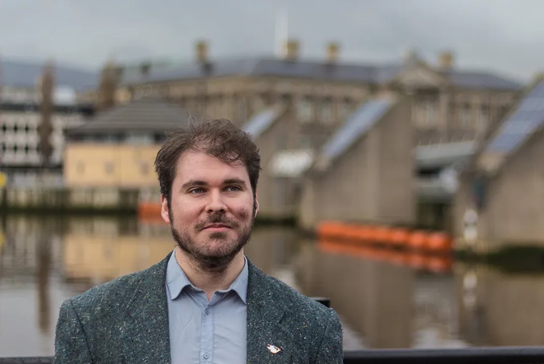 A man standing with a cityscape in the background