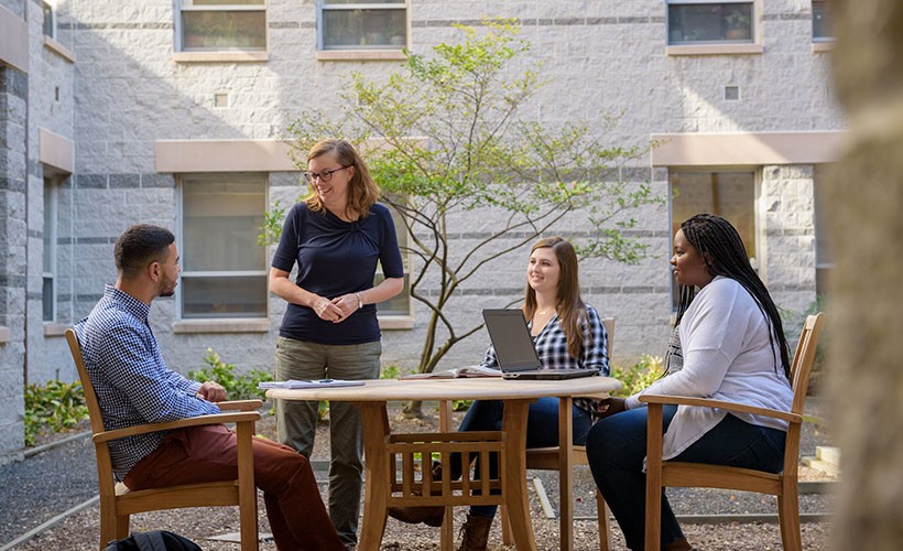 Professor Sally Scholz talks to students in the SAC courtyard.