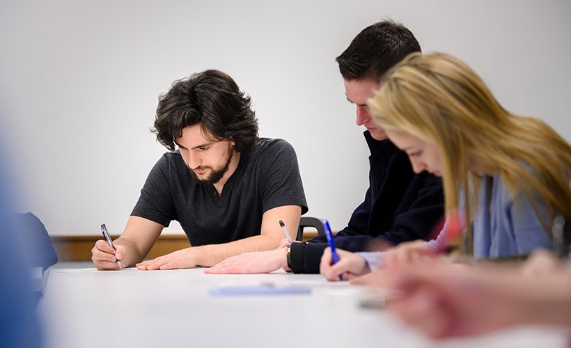 Students work in a classroom.