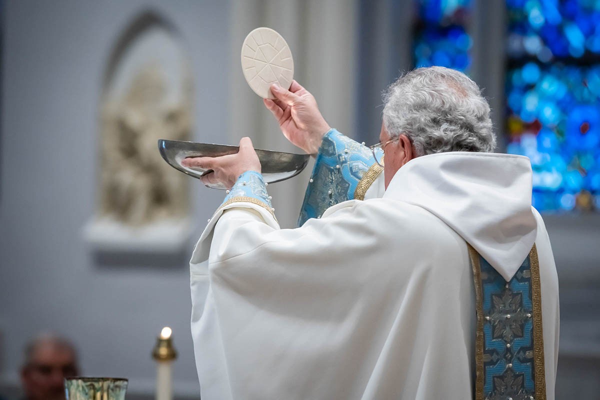 Father Peter holding the Eucharist