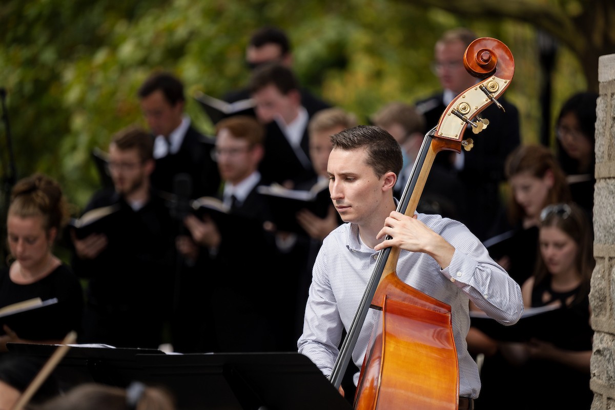 Male student playing cello at mass
