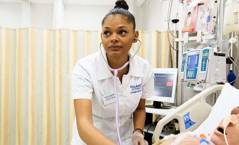 Nursing student stands<br/>at bedside in critical care unit
