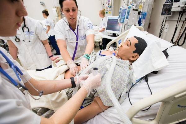 Nursing students simulate a scenario using a mannequin