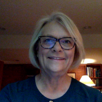 Female smiling with blonde hair and glasses