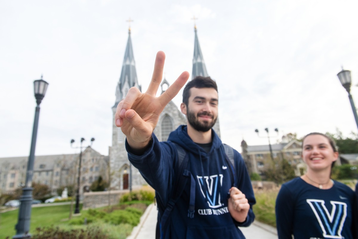 A Student Gives the "V's Up" Sign Near St. Thomas of Villanova Church