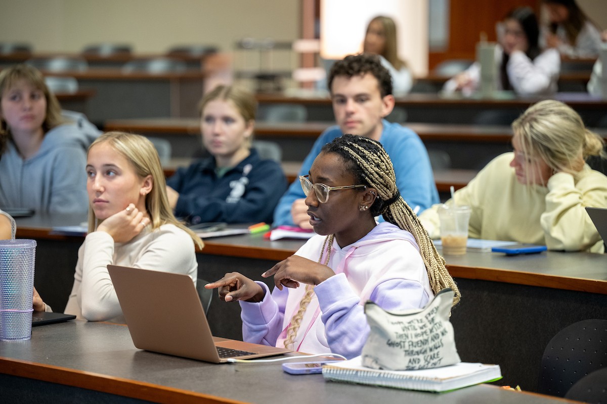 student points to laptop in lecture hall