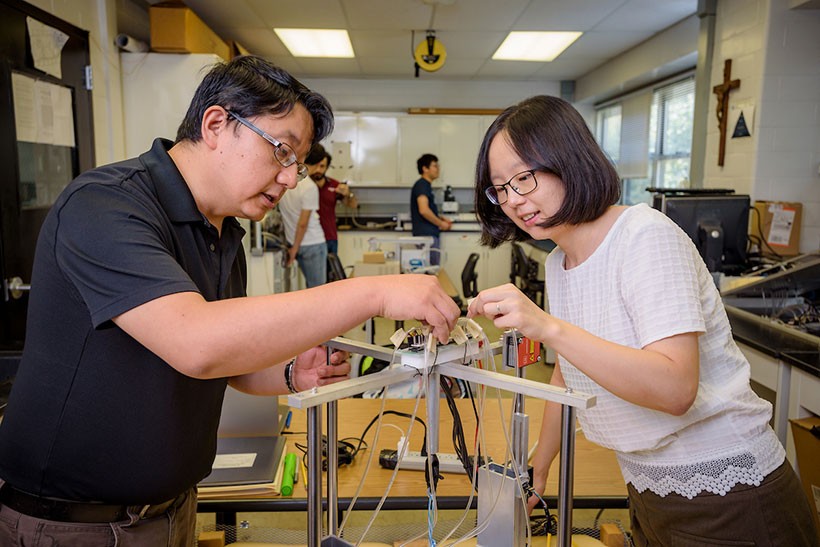 faculty-memebers-lab-experiment Faculty working together in lab