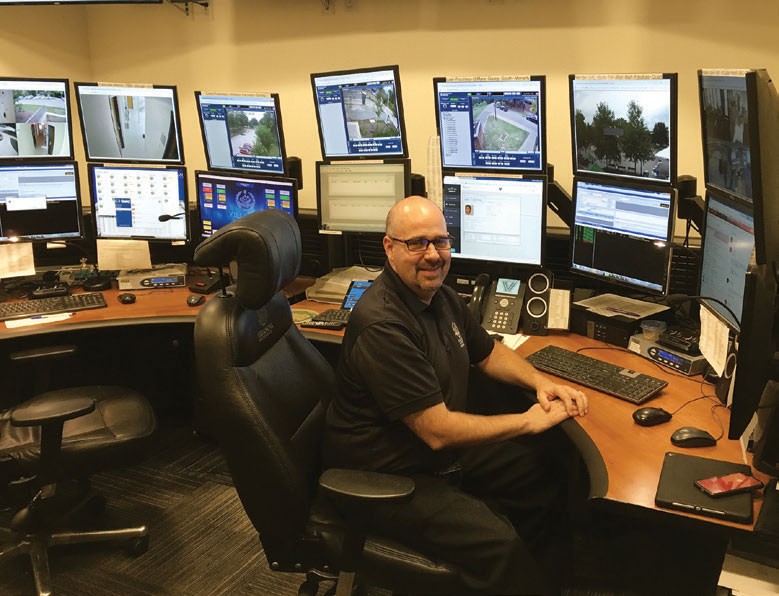 Public safety officer at desk with computer monitors