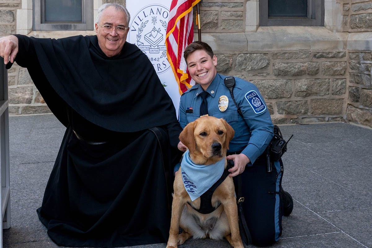 Taffy posing with Father Peter and her owner Amy Lenahan