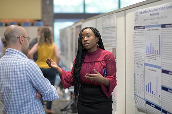 Student presenting research at poster session
