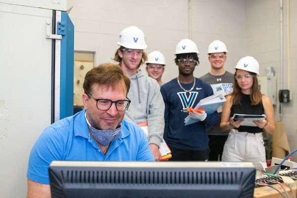 Engineering professor and students viewing computer