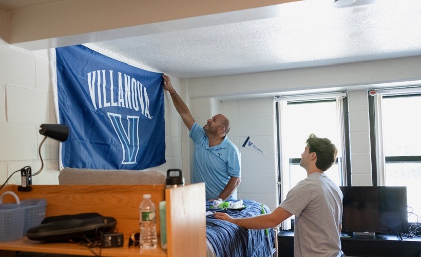 A student and his father set up a residence hall room. 